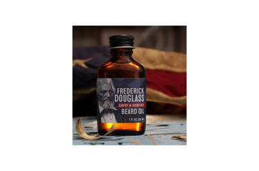 A bottle of Wolf & Iron beard oil with a label featuring a graphic of a bearded man's face, placed on a surface with a blurred background.