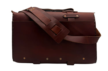 A dark brown leather satchel with double buckle straps and sliver-tone brass-toned hardware, shown against a plain white background.