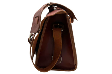 A dark brown leather satchel with double buckle straps and sliver-tone brass-toned hardware, shown against a plain white background.
